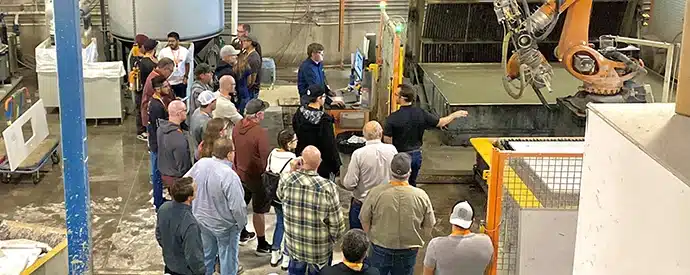 Professionals watching a robotic fabrication demonstration